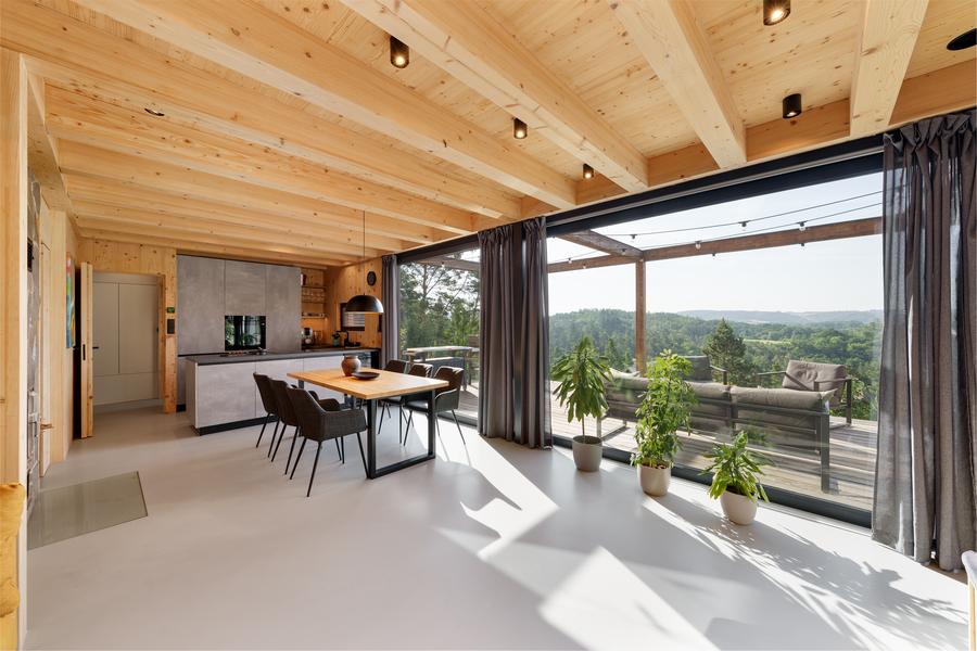 The open-plan living and dining room, sliding doors onto the terrace and the valley beyond