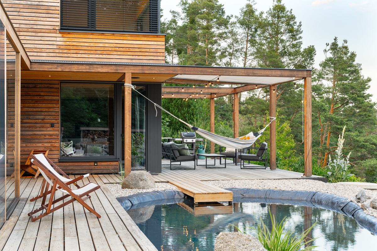 Terrasse und Schwimmteich, unter der Pergola die Hängematte