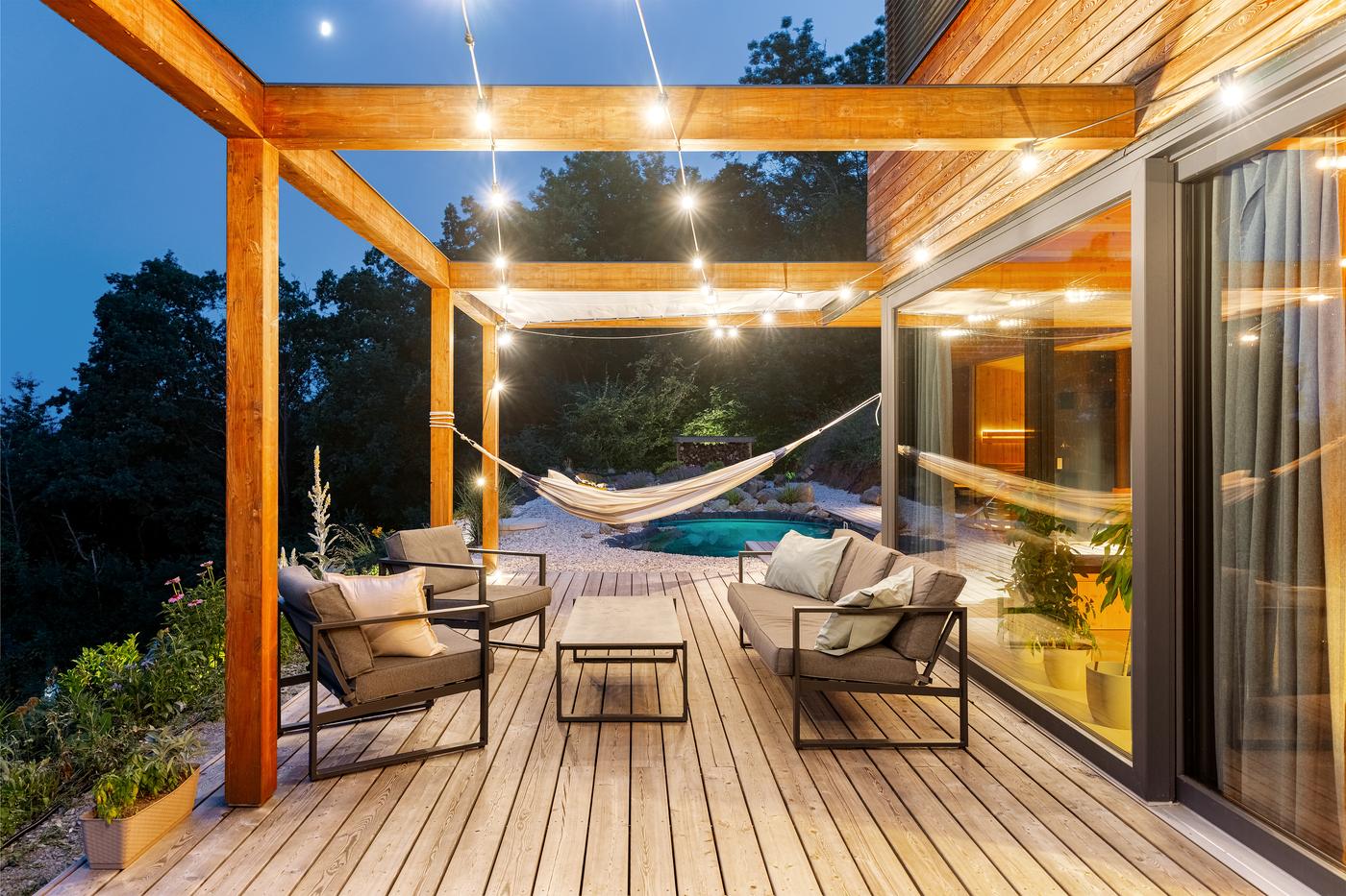 The terrace at twilight, string lights strung above the seating